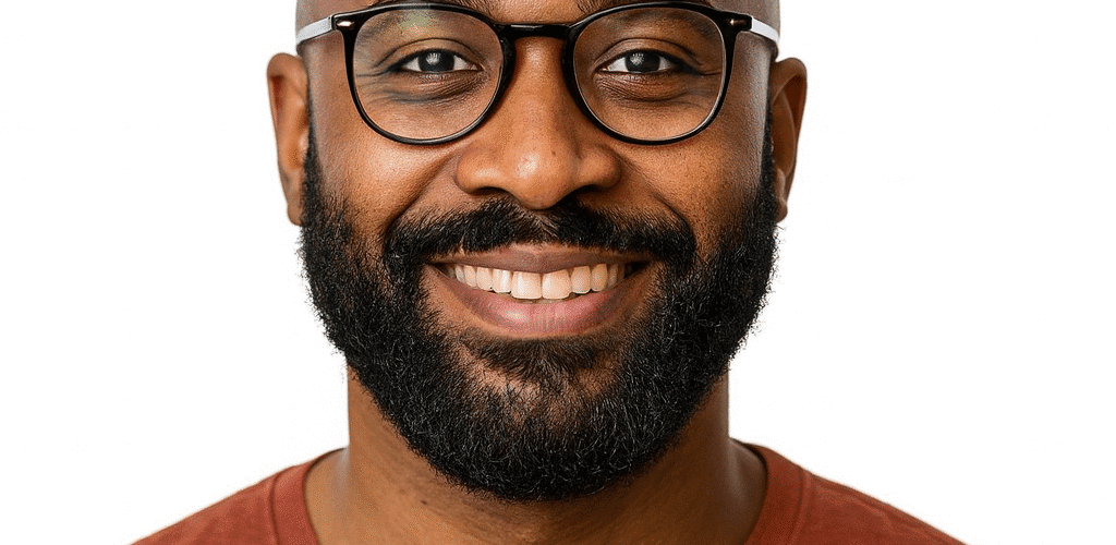 Smiling man with glasses and a beard in a brown sweater.